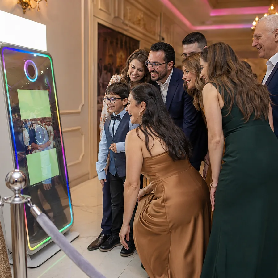 Famille de trois générations posant devant la borne miroir